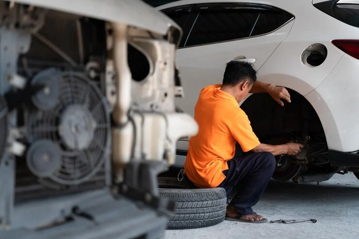 En bilmekaniker sjekker tilstanden til en bils bremseskiver.